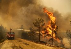 A firefighter extinguishes a forest fire near the town of Manavgat, east of the resort city of Antalya, Turkey, July 30, 2021. REUTERS/Kaan Soyturk