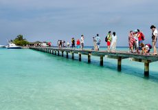 Chinese tourist walk on foot bridge over the sea in Maldives on Jan. 16, 2012.  More and more Chinese tourists go to Maldives for holidays. (Imaginechina)